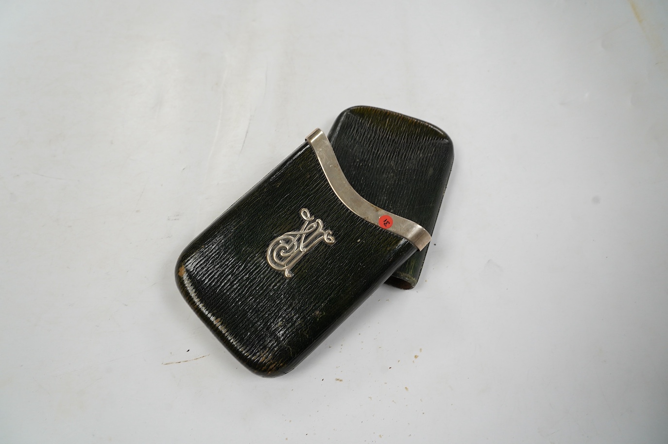 An Edwardian silver mounted green leather cigar case with crest and motto 'Candidior Nive' (whiter than snow), Alfred Clark, London, 1903, retailed by Clark of New Bond Street, 13.7cm. Condition - poor to fair